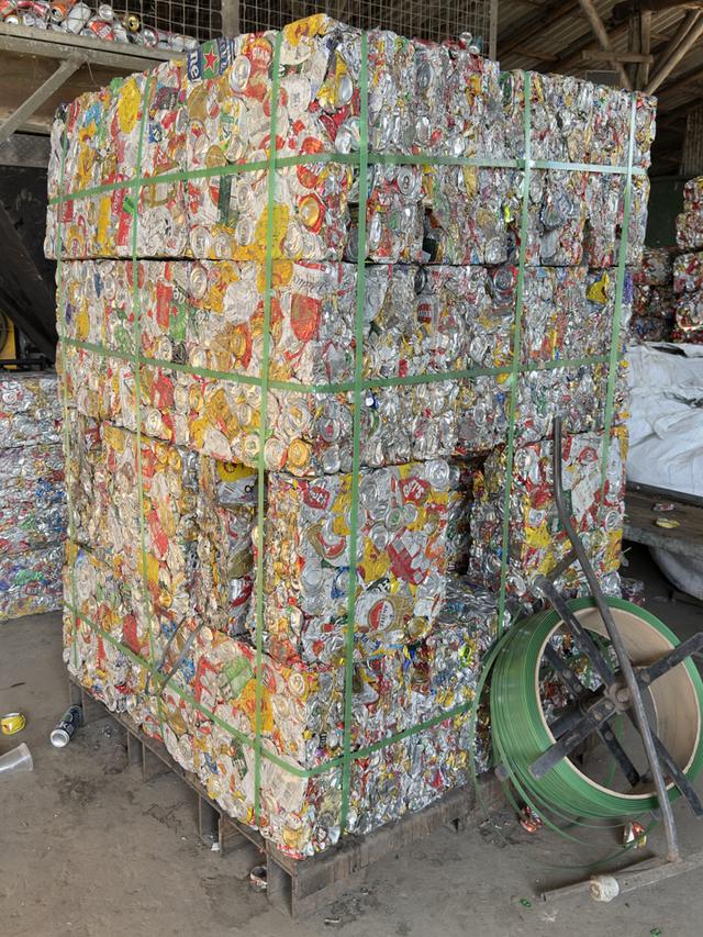 Fardos de latas de alumínio prensadas e amarradas, prontos para destinação.
