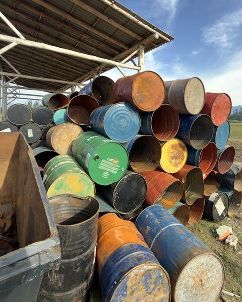 Tambores metálicos industriais empilhados na área coberta do pátio da RF Metais.